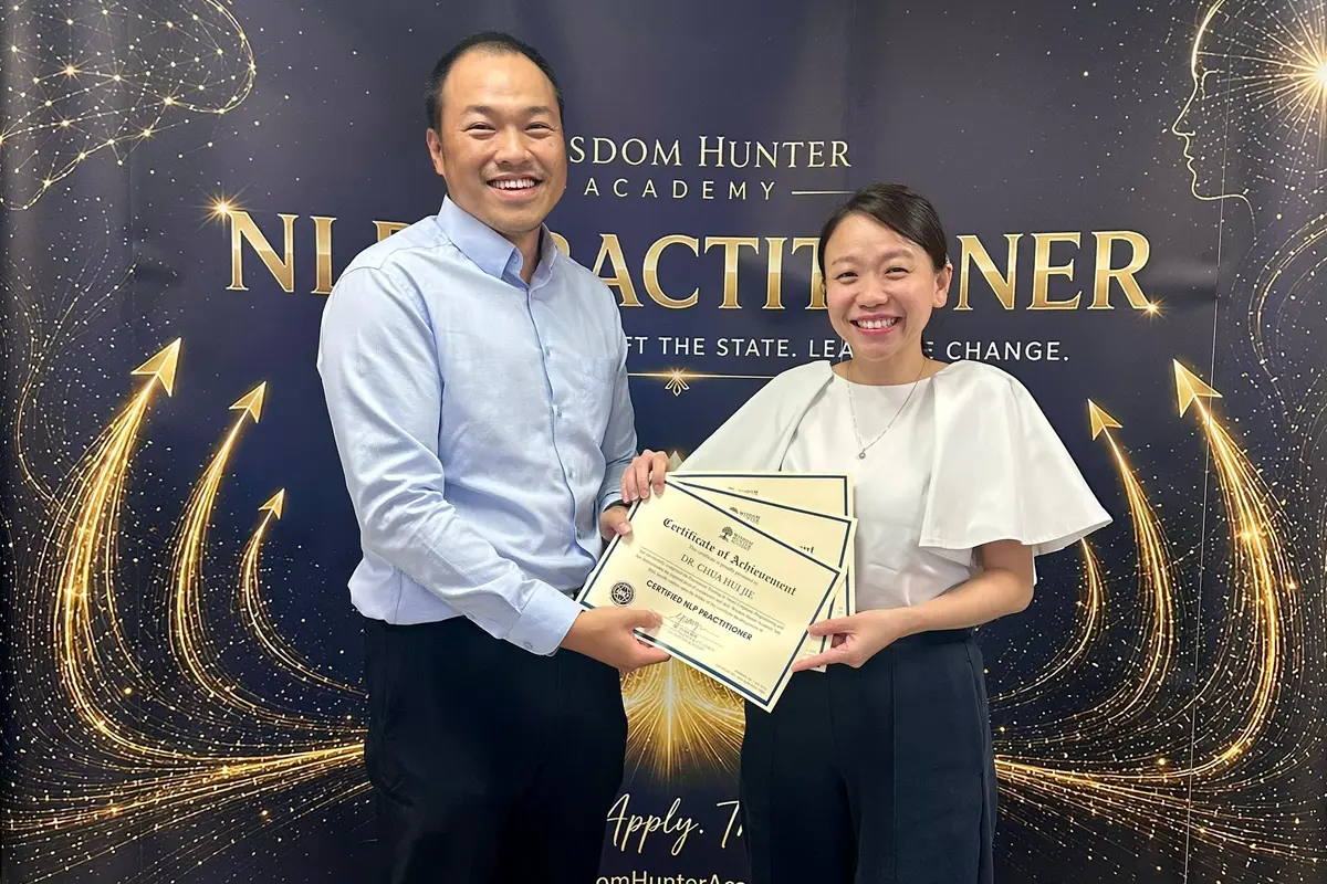 Participant receiving certificates after completing the NLP Practitioner programme