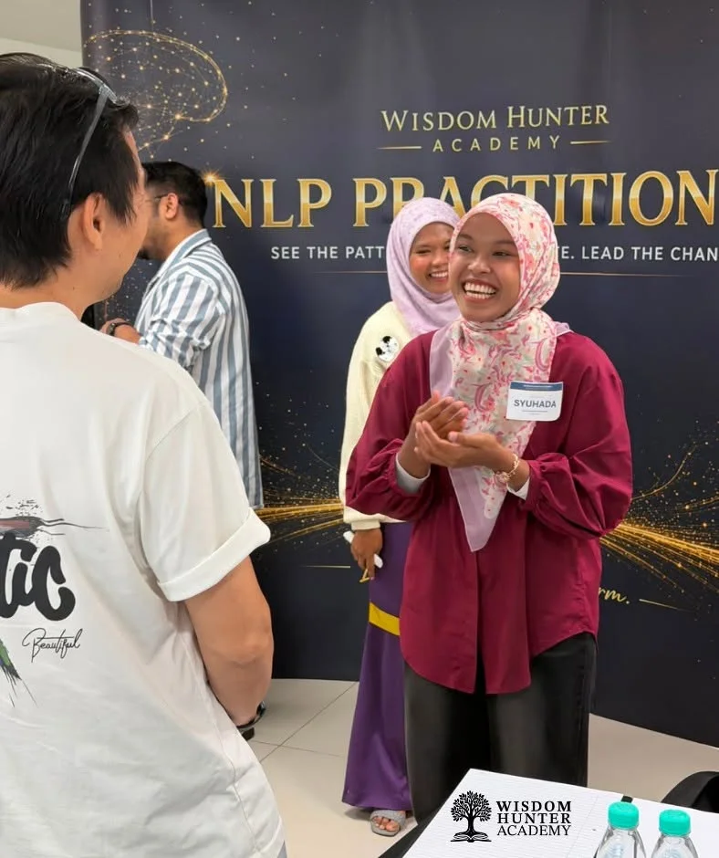 An NLP Practitioner participant laughing during an interactive learning exercise